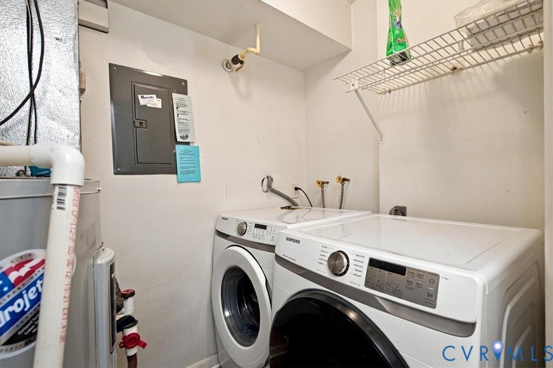 Dedicated laundry area featuring front-loading machines, wall-mounted wire shelving, and an accessible electrical panel