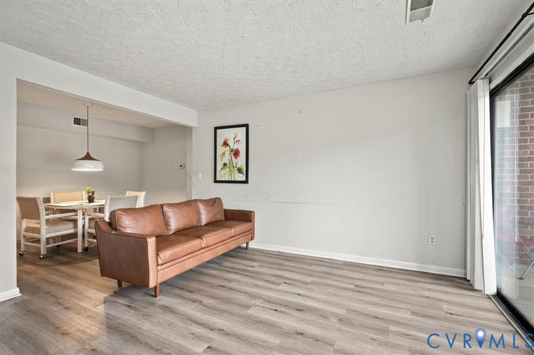 Wood-finish flooring, sliding glass door, pendant lighting, and neutral wall tones