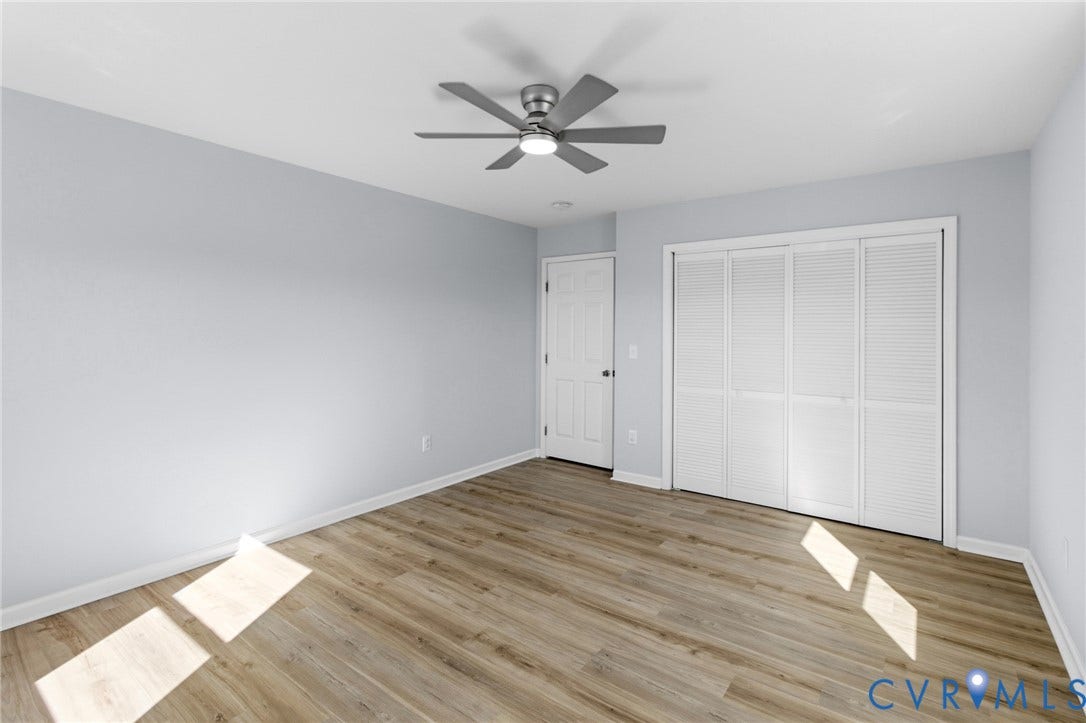 79 Dixie Drive, Mathews, VA 23050 Neutral-toned walls, wood-finish flooring, ceiling fan with integrated light, and a double-door closet with louvered panels