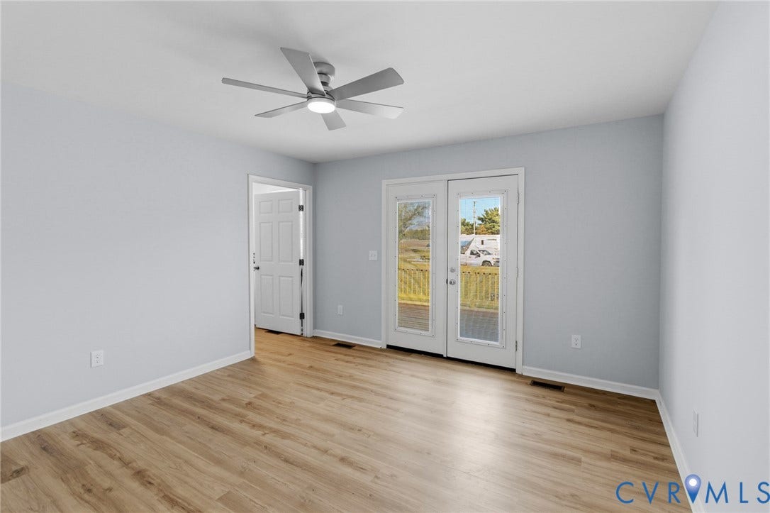 79 Dixie Drive, Mathews, VA 23050 Interior space featuring wood-finish flooring, a multi-pane glass door, a neutral color palette, and a multi-blade ceiling fan with integrated lighting