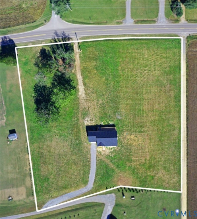 79 Dixie Drive, Mathews, VA 23050 Aerial perspective of a sprawling lot featuring a paved driveway, extensive open acreage, and a collection of mature trees