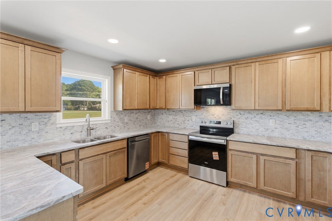 79 Dixie Drive, Mathews, VA 23050 Kitchen featuring shaker-style wood cabinetry, stone-finish countertops, mosaic tile backsplash, stainless steel appliances, and wood-finish flooring