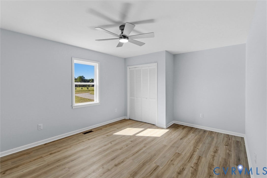 79 Dixie Drive, Mathews, VA 23050 Interior room featuring wood-finish flooring, a multi-blade ceiling fan with integrated lighting, and a bifold closet door
