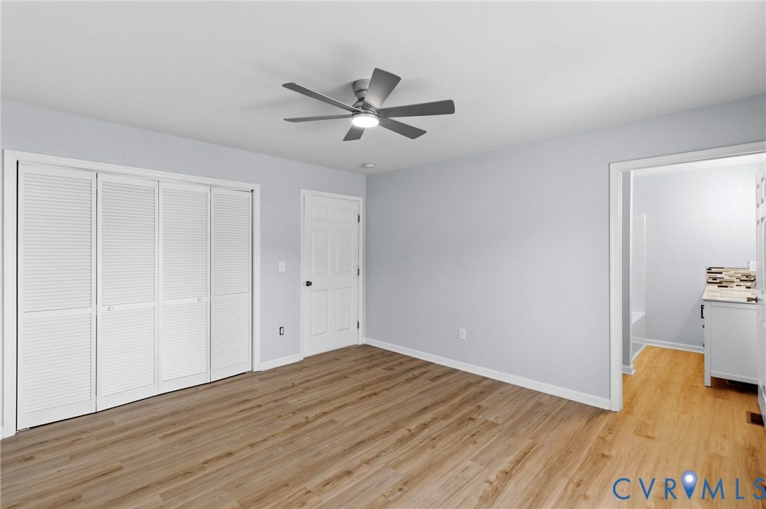 79 Dixie Drive, Mathews, VA 23050 Interior room featuring wood-finish flooring, a multi-blade ceiling fan with integrated lighting, and louvered bi-fold closet doors