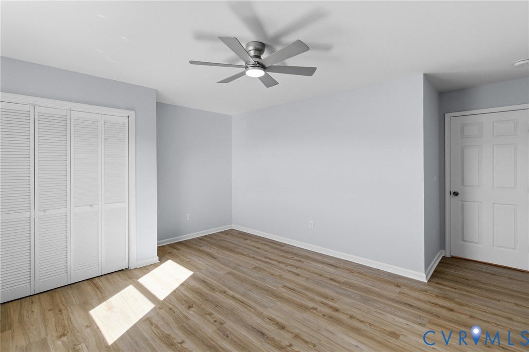 79 Dixie Drive, Mathews, VA 23050 Interior space featuring wood-finish flooring, neutral wall paint, bi-fold closet doors, a six-panel interior door, and a multi-blade ceiling fan with integrated lighting