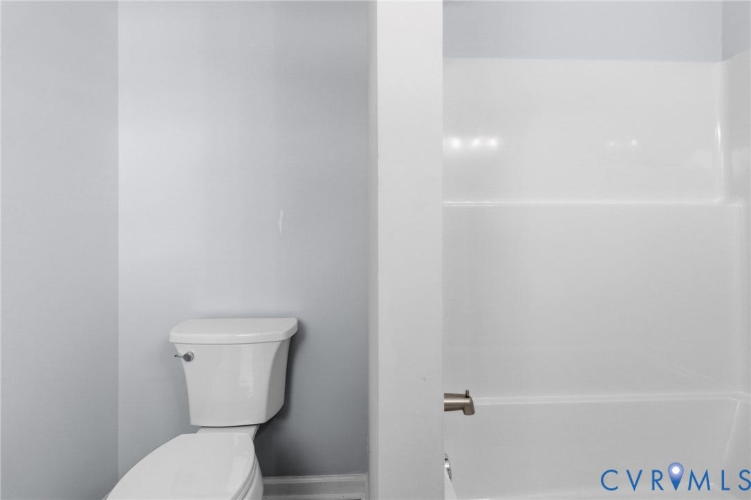 79 Dixie Drive, Mathews, VA 23050 Full bathroom featuring a white porcelain toilet and a tub-shower combination with a white surround and metal faucet fixture