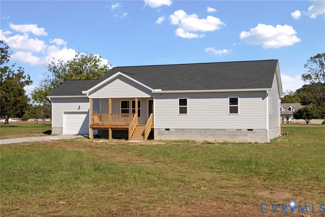 79 Dixie Drive, Mathews, VA 23050 Single-story residence featuring horizontal vinyl siding, an asphalt shingle roof, a front-facing attached garage, and a covered wooden porch
