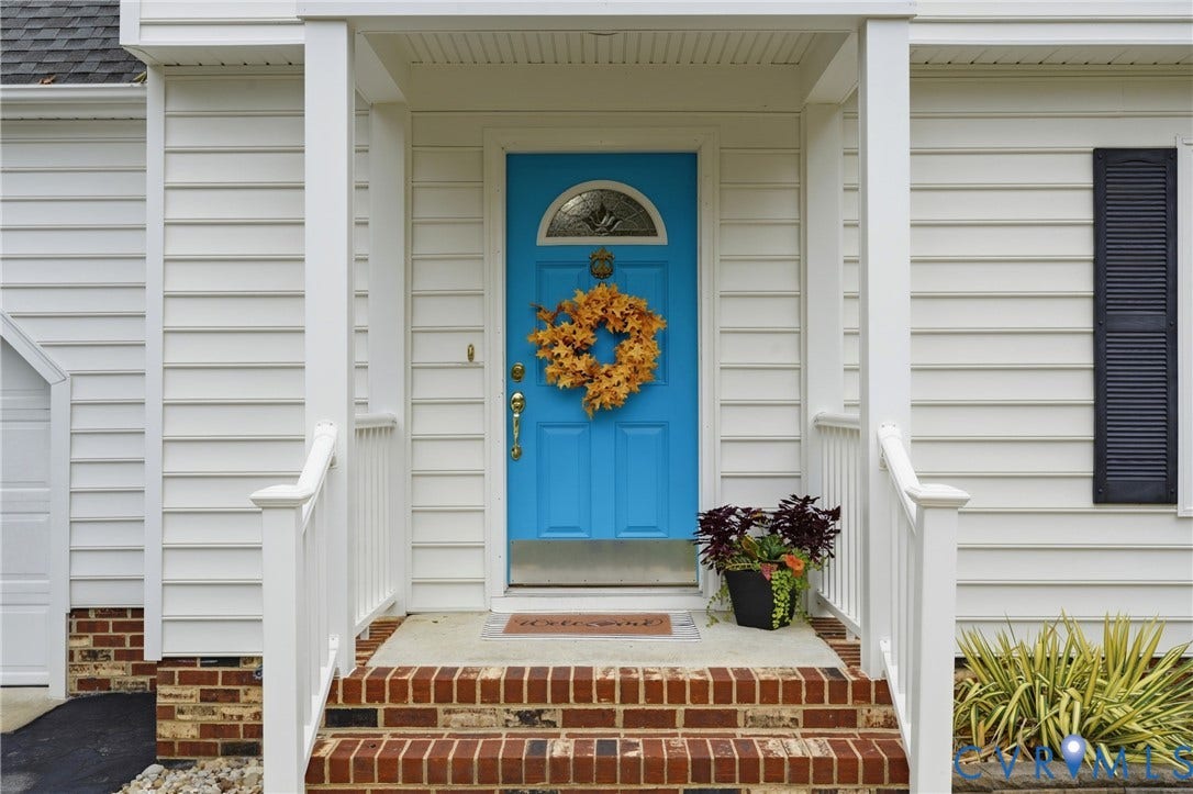 14800 Highberry Woods Drive, Midlothian, VA 23112 Front entrance featuring white lap siding, brick foundation detailing, a solid door with a semi-circular glass insert, and a covered porch with white railing