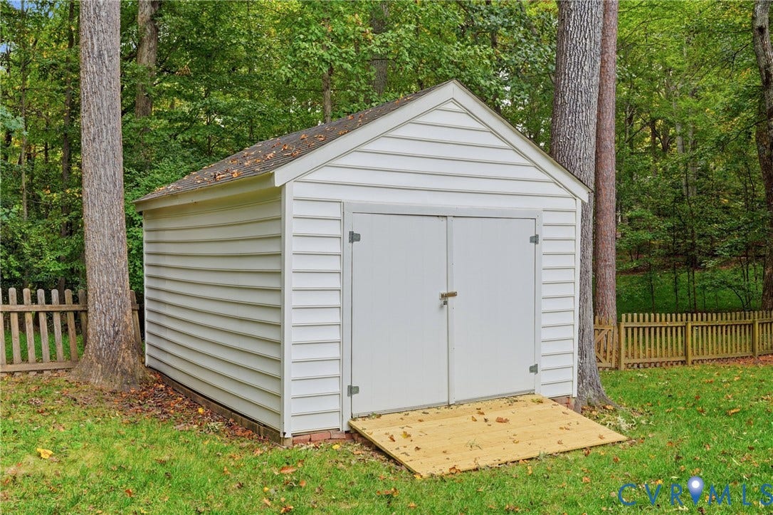 14800 Highberry Woods Drive, Midlothian, VA 23112 Freestanding outdoor storage shed featuring white horizontal siding, a gabled roof, double doors, and an integrated wooden ramp