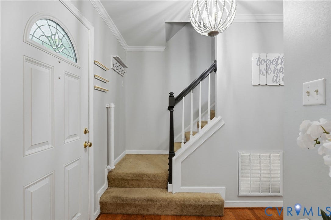14800 Highberry Woods Drive, Midlothian, VA 23112 Foyer entrance featuring a front door with an arched glass transom, a decorative beaded light fixture, and a staircase with a dark-finished handrail and white balusters