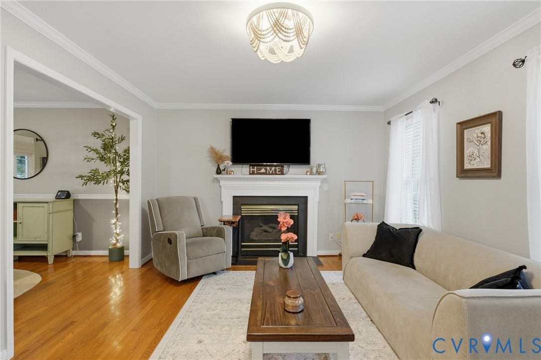 14800 Highberry Woods Drive, Midlothian, VA 23112 Living area featuring a fireplace with a white mantel, wood-finish flooring, crown molding, and a tiered beaded flush-mount light fixture
