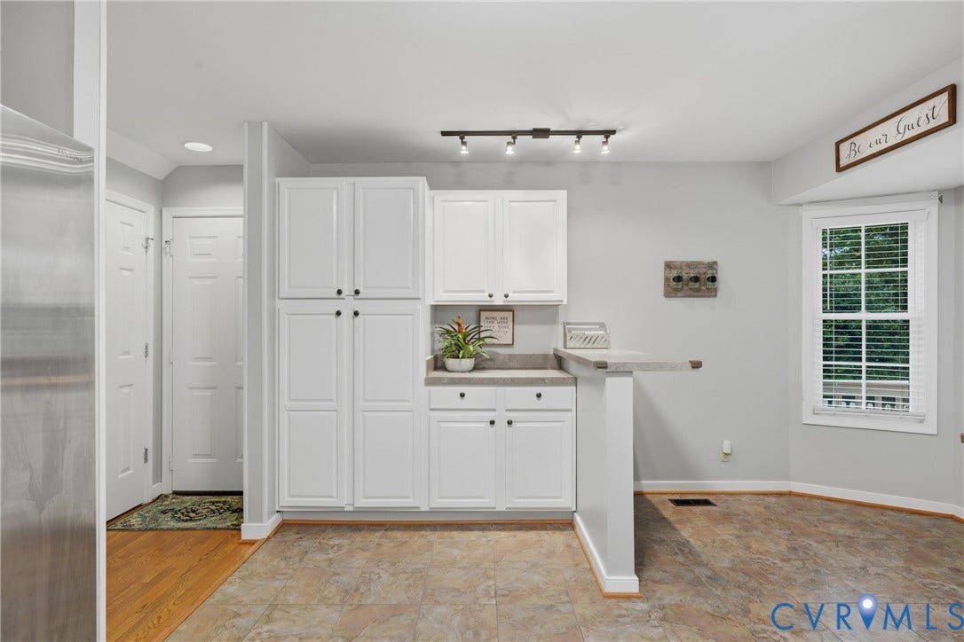 14800 Highberry Woods Drive, Midlothian, VA 23112 White cabinetry with ample storage, stone-finish countertops, multi-directional track lighting, and a multi-pane window
