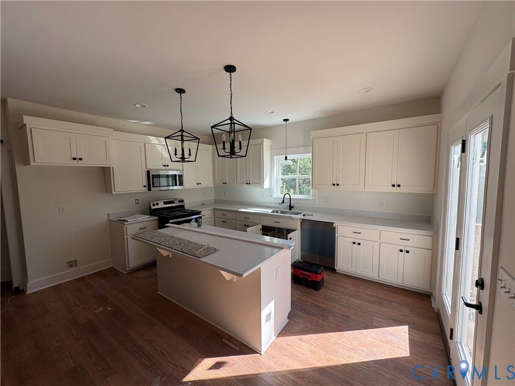15205 Lebanon Road, Parson's Retreat, Disputanta, VA 23842 Kitchen featuring shaker-style cabinetry, quartz countertops, wood-finish flooring, geometric pendant lighting, and stainless steel appliances