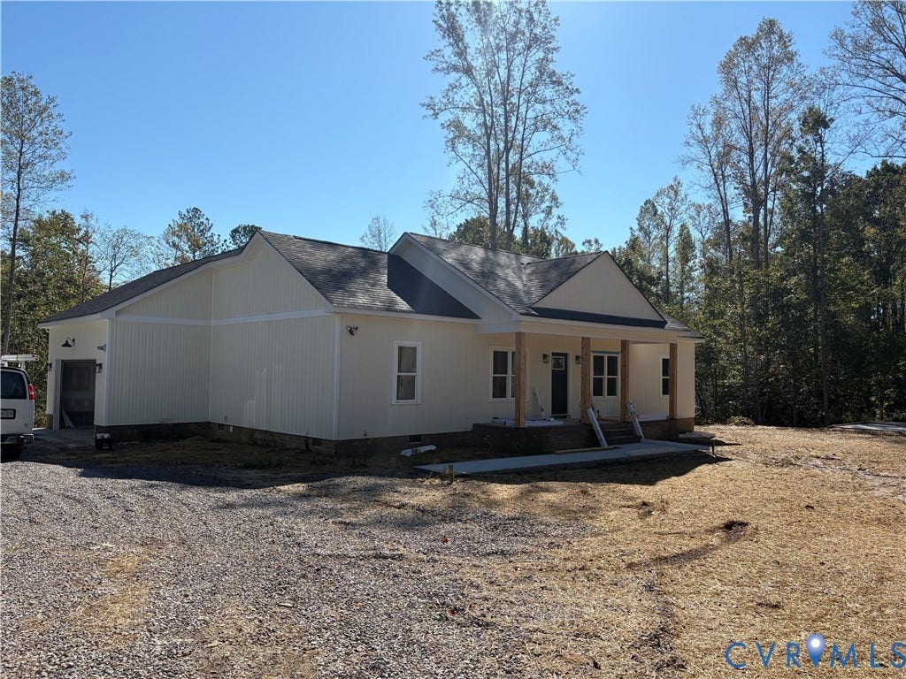 15205 Lebanon Road, Parson's Retreat, Disputanta, VA 23842 Single-story residence featuring light-colored vertical siding, a covered front porch with wood-finished support columns, an asphalt shingle roof, and a gravel driveway