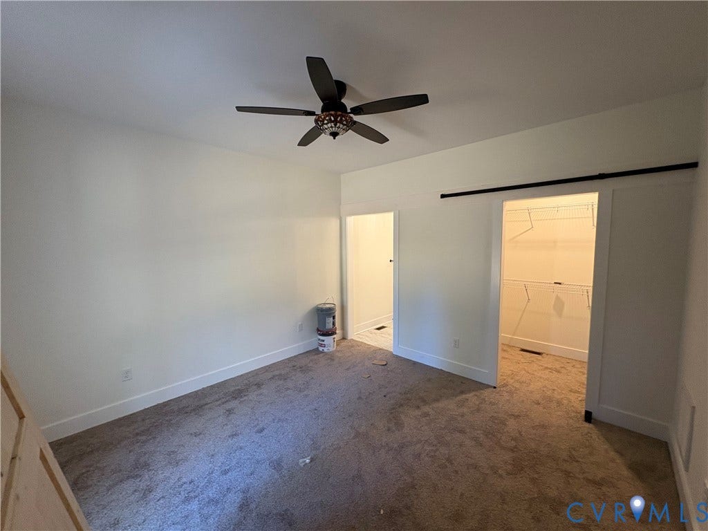 15205 Lebanon Road, Parson's Retreat, Disputanta, VA 23842 Interior space featuring carpeted flooring, a ceiling fan with integrated lighting, and a closet with a sliding barn-style door