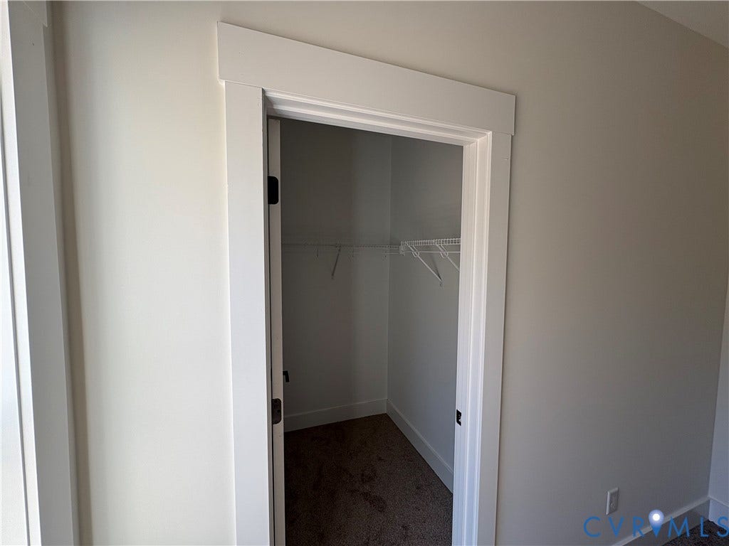 15205 Lebanon Road, Parson's Retreat, Disputanta, VA 23842 Walk-in closet featuring white wooden door casing, neutral wall paint, carpeted flooring, and integrated wire shelving