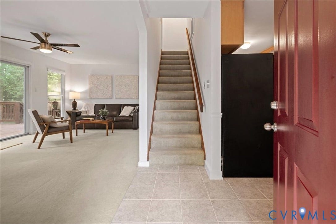 10209 Francill Court, North Chesterfield, VA 23236 Entryway featuring ceramic tile flooring, a painted red front door, and a staircase with a wooden handrail