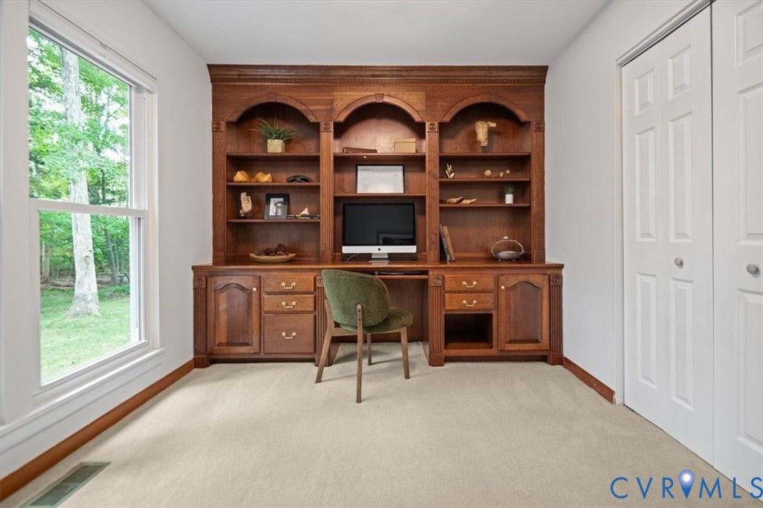 10209 Francill Court, North Chesterfield, VA 23236 Built-in wooden cabinetry featuring arched shelving and lower storage, dual-panel closet doors, and large window with exterior tree exposure