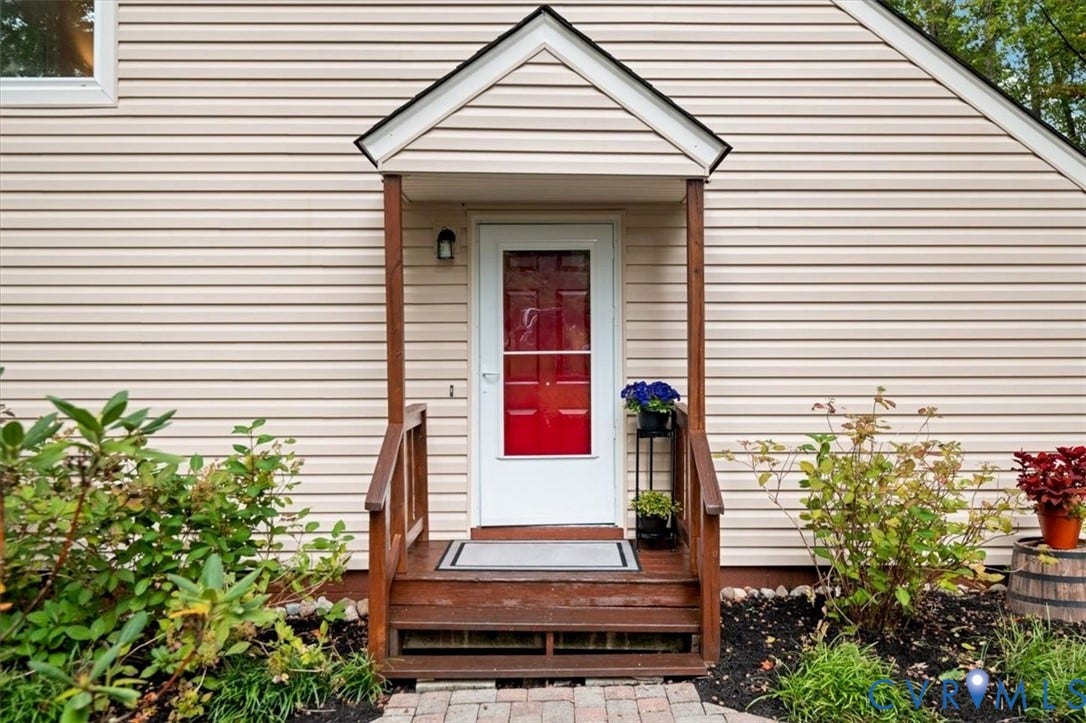 10209 Francill Court, North Chesterfield, VA 23236 Entrance featuring a gabled portico, wood-finish railing, horizontal vinyl siding, and a white exterior door with a glass insert