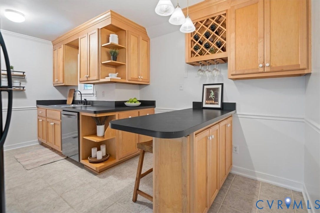 10209 Francill Court, North Chesterfield, VA 23236 Kitchen featuring light-finish cabinetry with built-in wine storage and open shelving, dark countertops, a stainless steel dishwasher, and three pendant lights