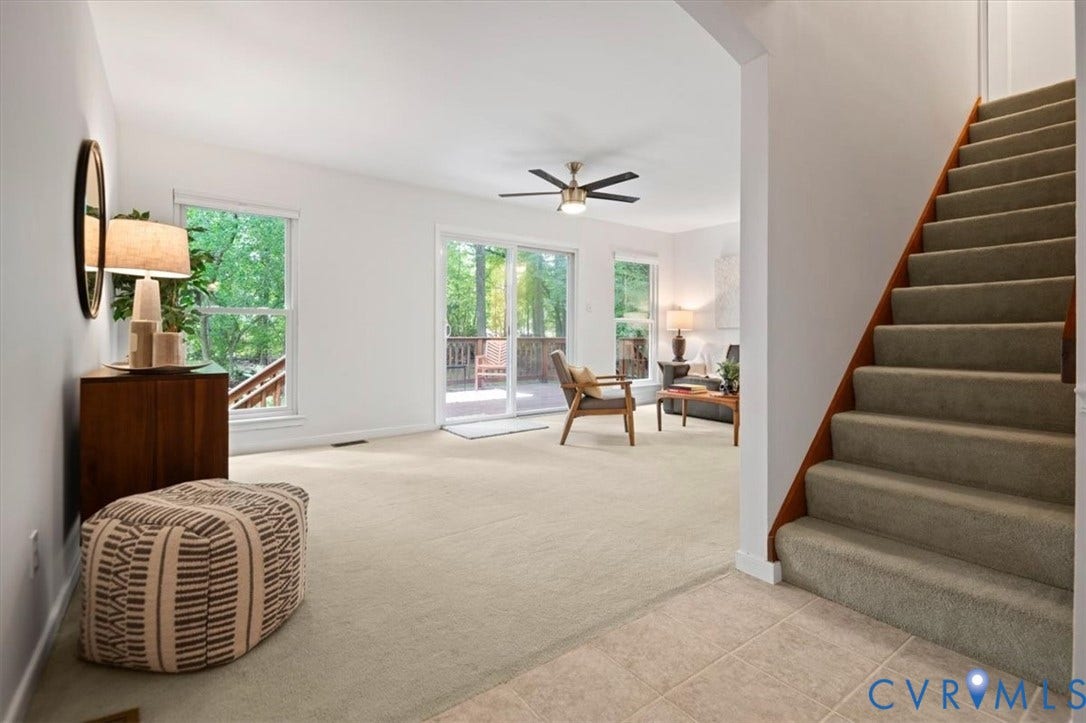 10209 Francill Court, North Chesterfield, VA 23236 Carpeted living area featuring a ceiling fan, sliding glass doors, and a staircase with wooden handrails