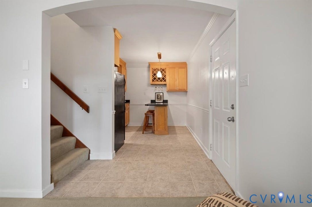 10209 Francill Court, North Chesterfield, VA 23236 Arched entryway featuring ceramic tile flooring, a staircase with a wood handrail, and built-in wood cabinetry with integrated wine storage