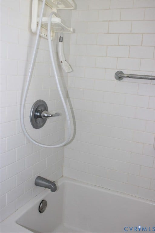 905 Williamsburg Road, Colonial Heights, VA 23834 White subway tile surround, polished chrome single-handle faucet, integrated tub spout, and a wall-mounted metal grab bar