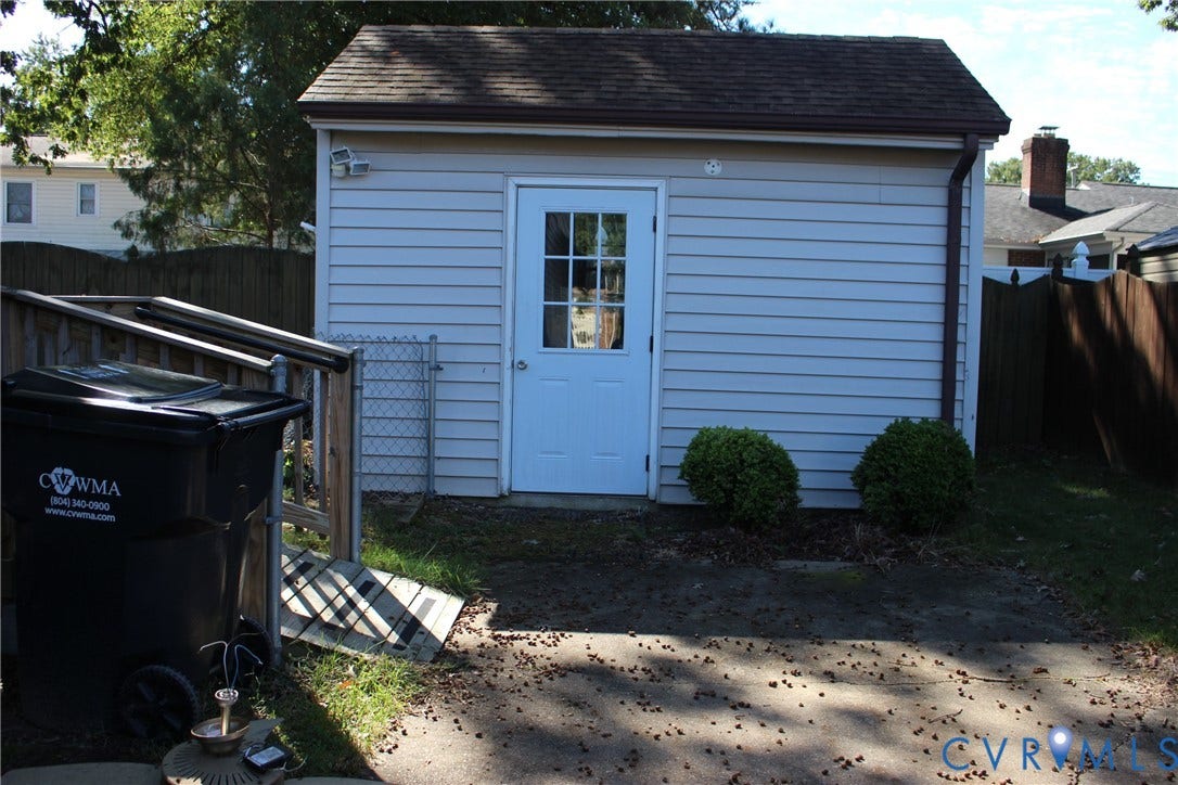 905 Williamsburg Road, Colonial Heights, VA 23834 Detached storage structure featuring horizontal siding, a gabled roof, and a central pedestrian door with paneled glass accents