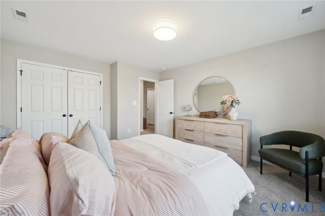 Neutral wall color, wall-to-wall carpeting, flush-mount ceiling lighting, and double-door reach-in closet with six-panel door design