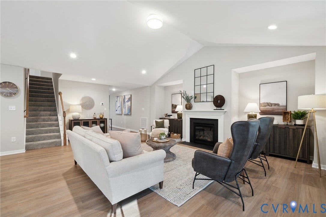 Vaulted ceilings, wood-finish flooring, recessed lighting, and a focal fireplace with a classic mantel