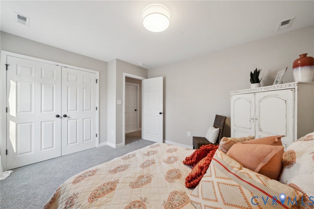 Neutral-toned interior featuring wall-to-wall carpeting, white six-panel interior doors, and a flush-mount drum ceiling light fixture