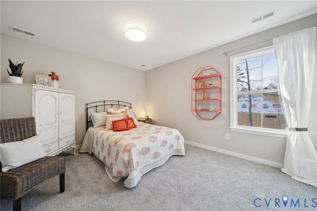 Neutral-toned interior featuring wall-to-wall carpeting, a multi-pane window with a single hung sash, and a flush-mount drum ceiling light fixture