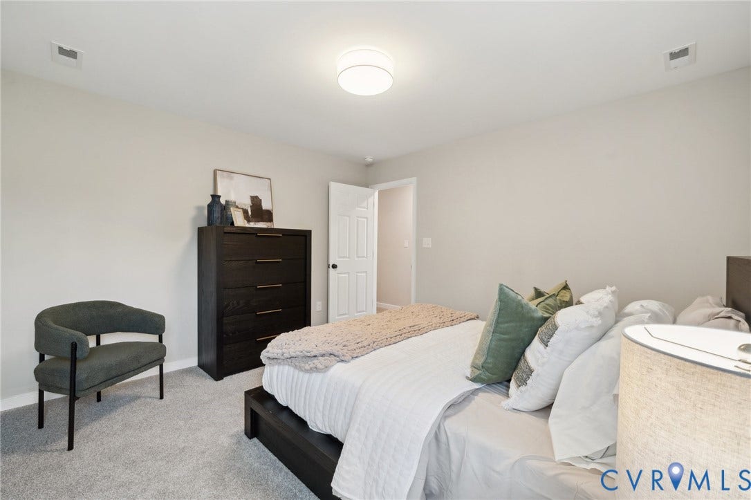 Neutral interior featuring wall-to-wall carpeting and a flush-mount drum ceiling light