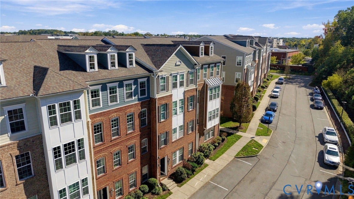 4223 Saunders Tavern Trail, #A, Henrico, VA 23233 Multi-story brick and siding facade with dormer windows, shingle roofing, and defined exterior lighting