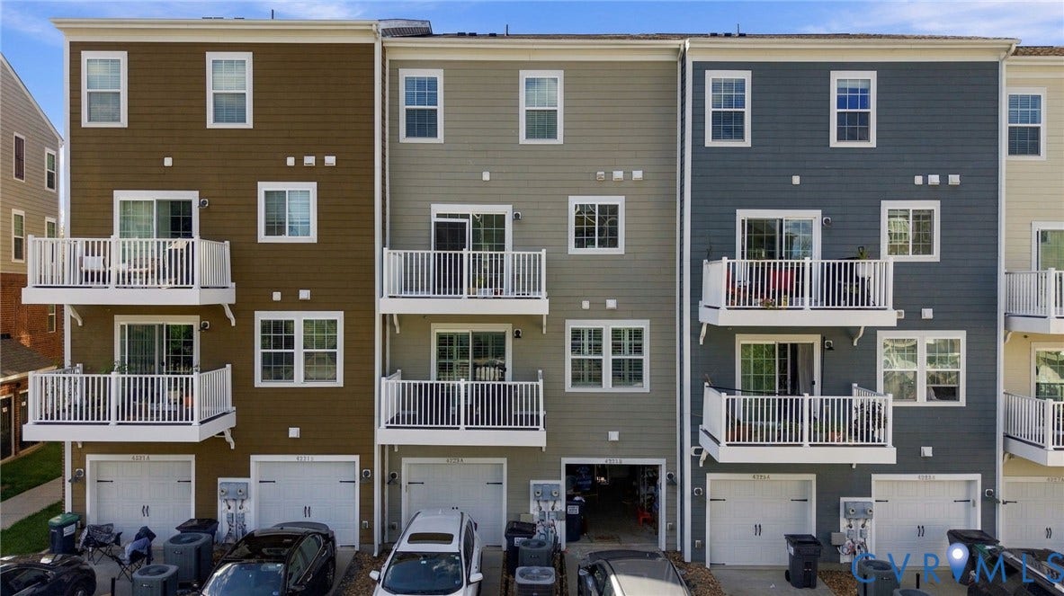 4223 Saunders Tavern Trail, #A, Henrico, VA 23233 Multi-story townhome exterior featuring horizontal siding, integrated ground-level garages, and stacked upper-level balconies with white railings