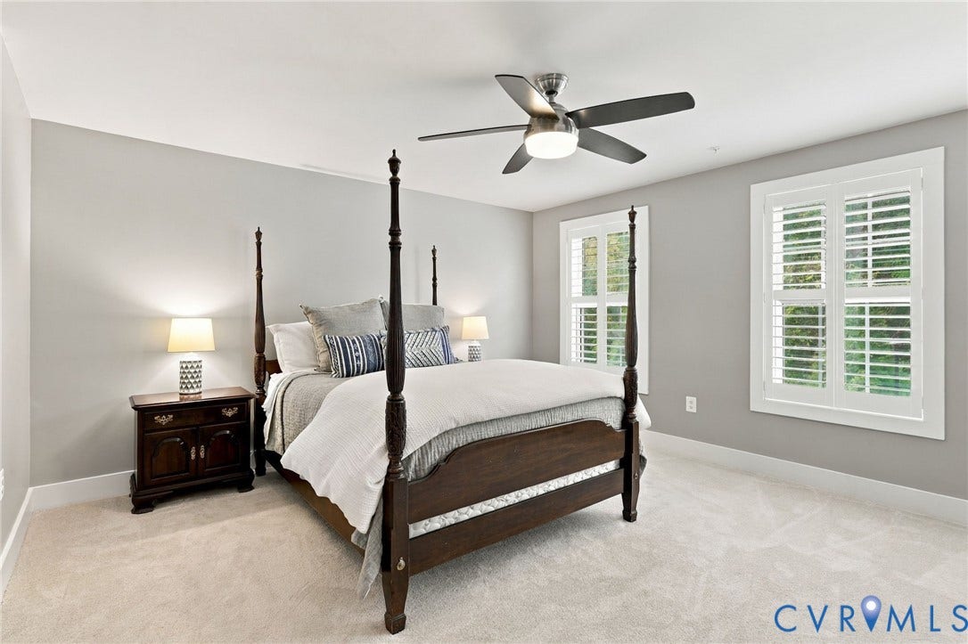 4223 Saunders Tavern Trail, #A, Henrico, VA 23233 Neutral-toned room featuring wall-to-wall carpeting, dual windows with plantation shutters, and a brushed nickel ceiling fan with an integrated light fixture