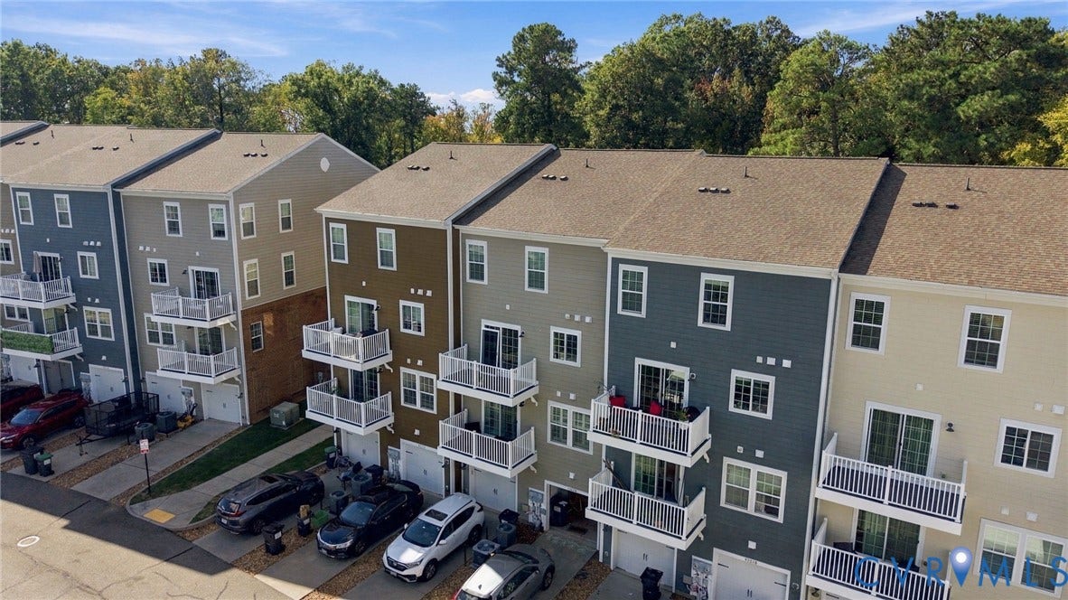 4223 Saunders Tavern Trail, #A, Henrico, VA 23233 Multi-story townhome exterior featuring horizontal lap siding, stacked private balconies with white railings, and attached single-car garages
