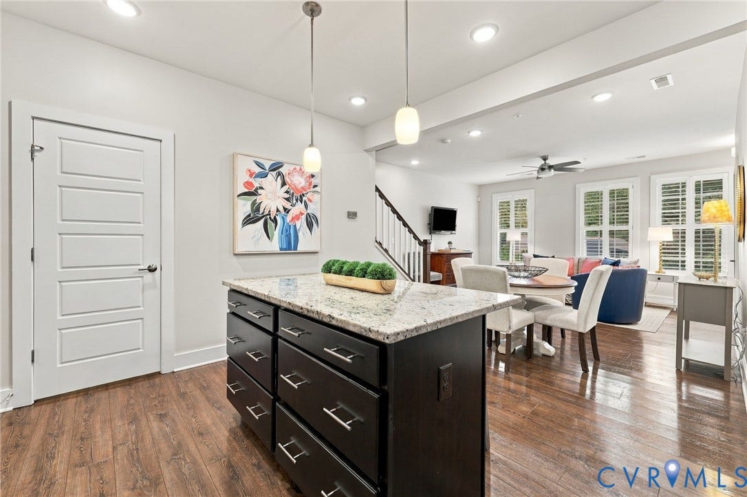 4223 Saunders Tavern Trail, #A, Henrico, VA 23233 Kitchen island with stone countertop, dark-finish cabinetry, wood-finish flooring, and two pendant lights