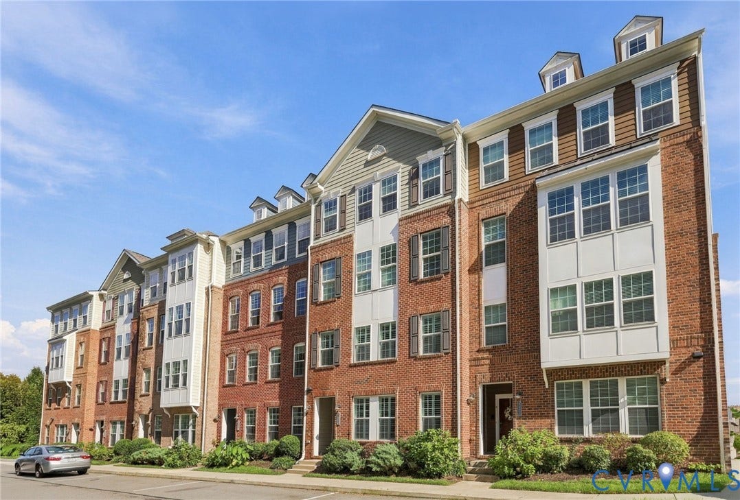 4223 Saunders Tavern Trail, #A, Henrico, VA 23233 Multi-level brick exterior featuring multi-pane windows, decorative shutters, dormer roof accents, and projecting bay windows