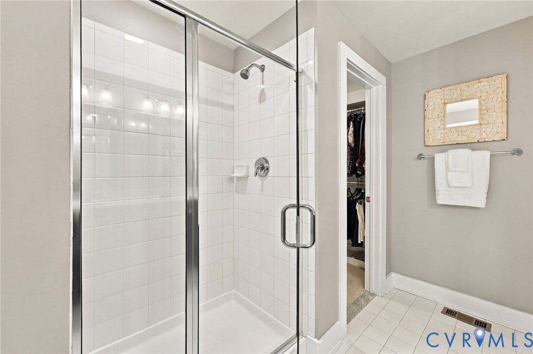 4223 Saunders Tavern Trail, #A, Henrico, VA 23233 Walk-in shower featuring a chrome-framed glass enclosure, white tile surround, and polished chrome shower fixtures with a matching towel bar