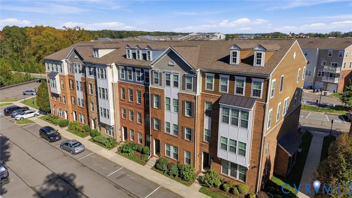 4223 Saunders Tavern Trail, #A, Henrico, VA 23233 Multi-story townhome exterior featuring brick and vertical siding, pitched rooflines with dormer windows, and bay window projections