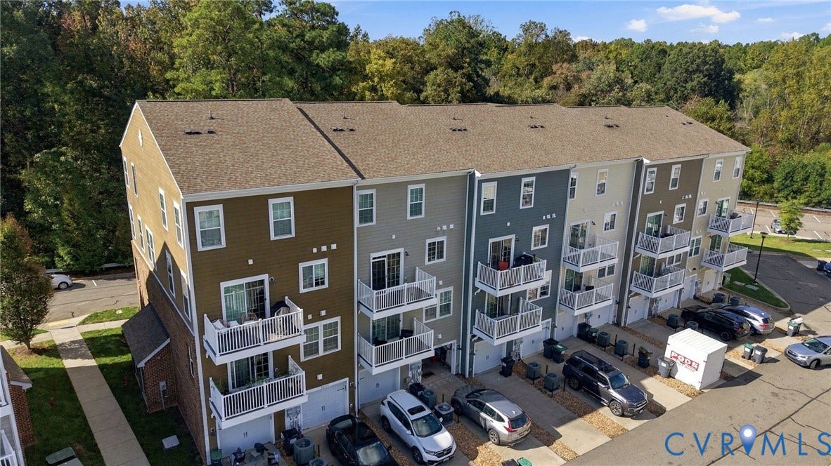 4223 Saunders Tavern Trail, #A, Henrico, VA 23233 Multi-story townhome complex featuring horizontal siding, asphalt shingle roofs, private elevated balconies with white railings, and attached ground-level garages