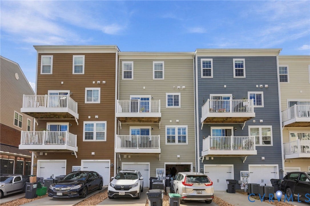 4223 Saunders Tavern Trail, #A, Henrico, VA 23233 Multi-level townhome exterior featuring horizontal lap siding, private upper-level balconies with white railings, and attached ground-level garages