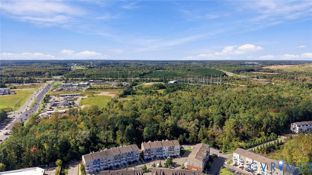 4223 Saunders Tavern Trail, #A, Henrico, VA 23233 Aerial perspective of multi-level residential structures featuring exterior stone and siding finishes, situated amidst wooded surroundings with proximity to established thoroughfares