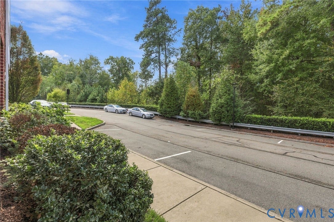 4223 Saunders Tavern Trail, #A, Henrico, VA 23233 Asphalt parking area featuring painted stalls, concrete curbing, and mature landscape borders
