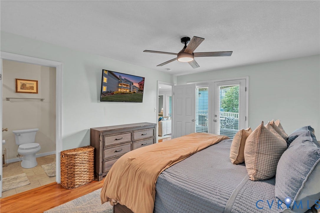 Wood-finish flooring, ceiling fan with integrated lighting, and glass-paneled double doors providing outdoor access