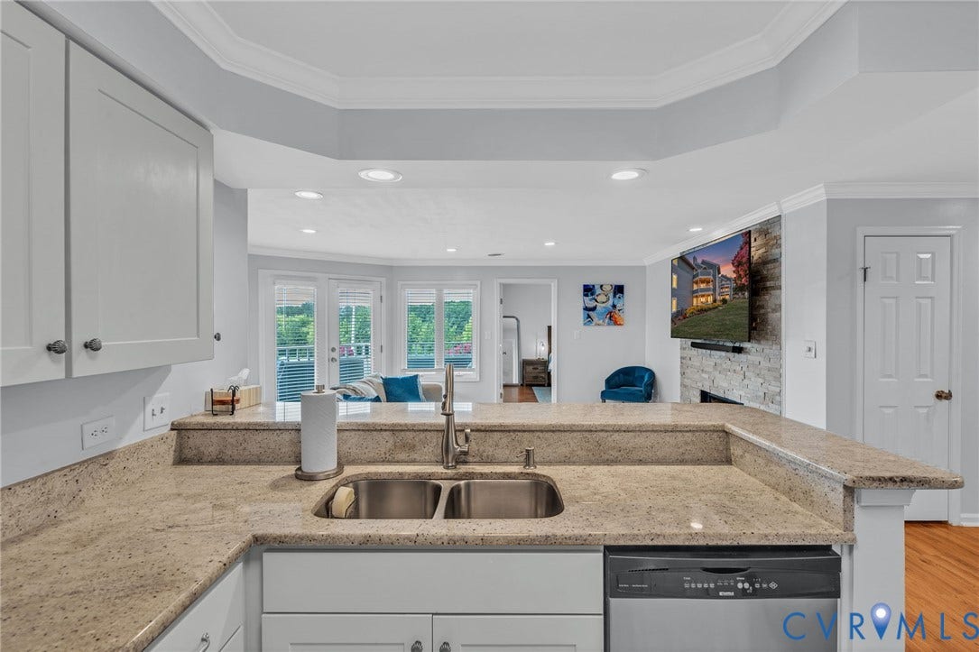 Kitchen featuring stone countertops, stainless steel dual-basin undermount sink, recessed lighting, and crown molding