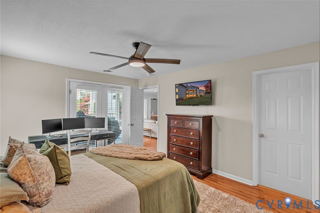 Wood-finish flooring, multi-pane glass door, and a ceiling fan with integrated lighting
