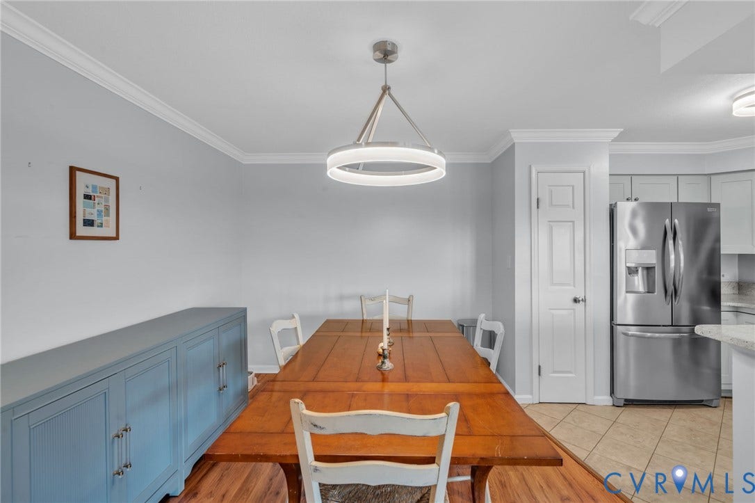 Dining area featuring a modern circular chandelier, built-in cabinetry, and wood-finish flooring