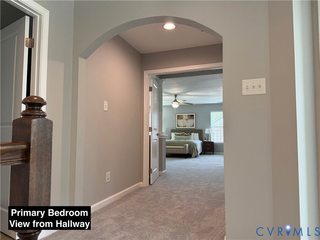 Arched entryway featuring neutral-toned wall paint, recessed lighting, and wall-to-wall carpeting